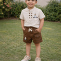 Boy wearing a beige short-sleeve shirt and brown cargo shorts two-piece set