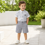 Young boy wearing a grey patterned mandarin-collar shirt and cargo shorts set