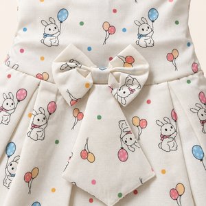 Close-up of waist bow and bunny balloon print on ivory baby dress