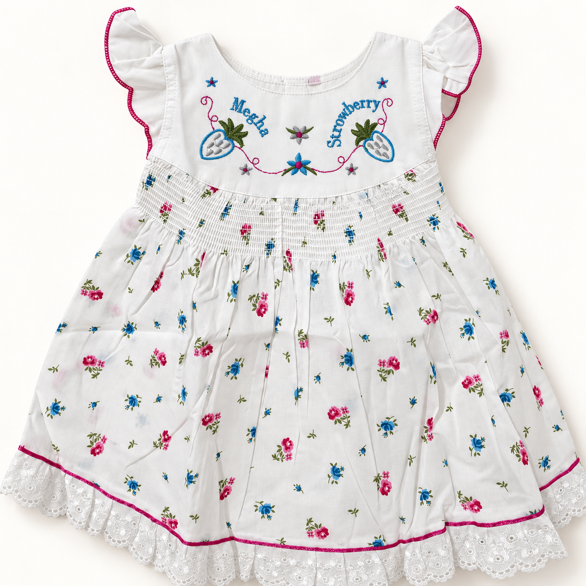 White floral baby dress showing embroidered bodice, shirred waist and lace trim