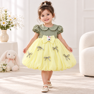 Toddler modeling sage green and lemon yellow bunny party dress from Inaabia 4-dress combo set