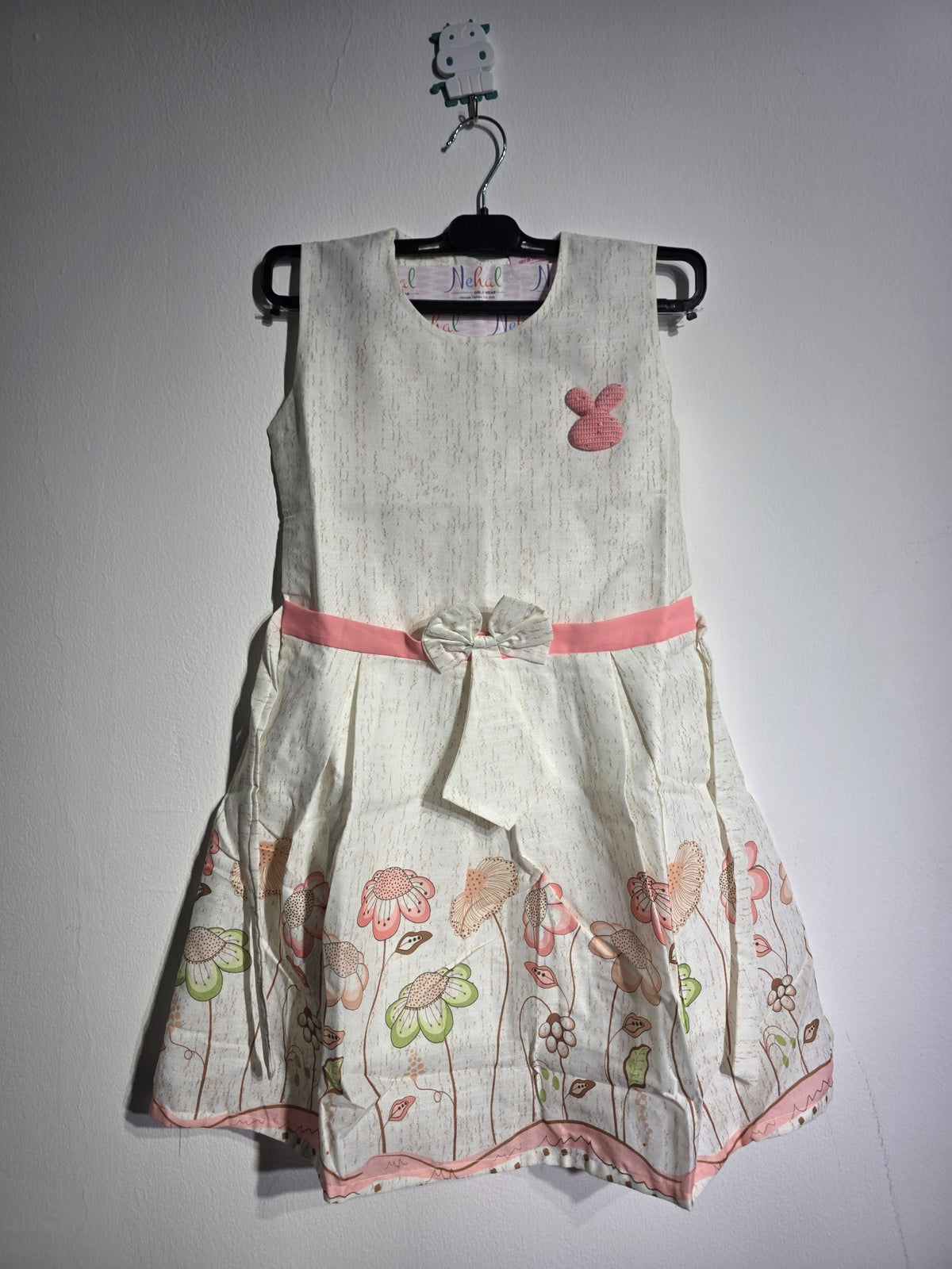 Close-up of Inaabia ivory floral girls dress showing pink bunny applique, textured bodice and waist bow