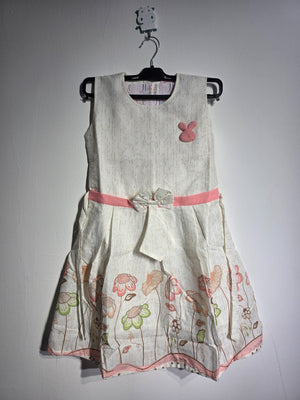 Close-up of Inaabia ivory floral girls dress showing pink bunny applique, textured bodice and waist bow