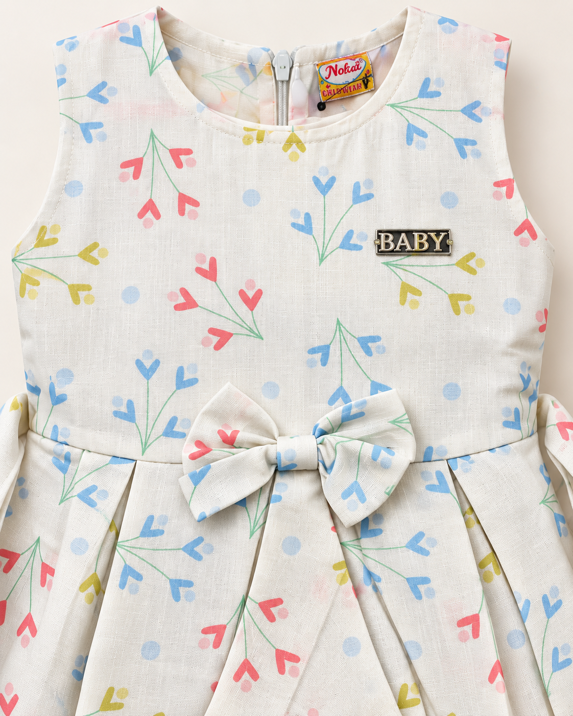 Close-up of ivory pastel sprig girls dress showing print, bow and chest detail