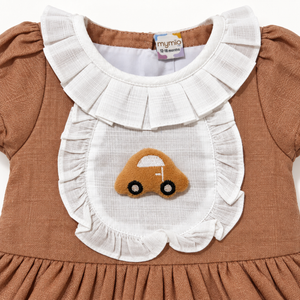Close-up of brown dress white ruffled bib and textured car applique