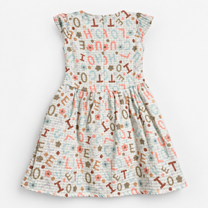 Back view of off-white textured alphabet and floral print girls dress with short cap sleeves and centered zipper