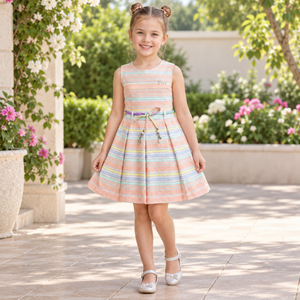 Girl wearing pastel striped sleeveless dress with pleated skirt and multicolor charm belt in a garden setting